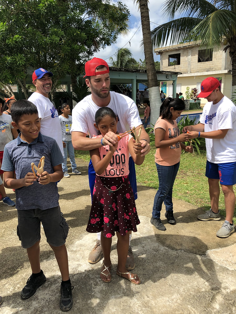 A group of people standing around a group of children at home.