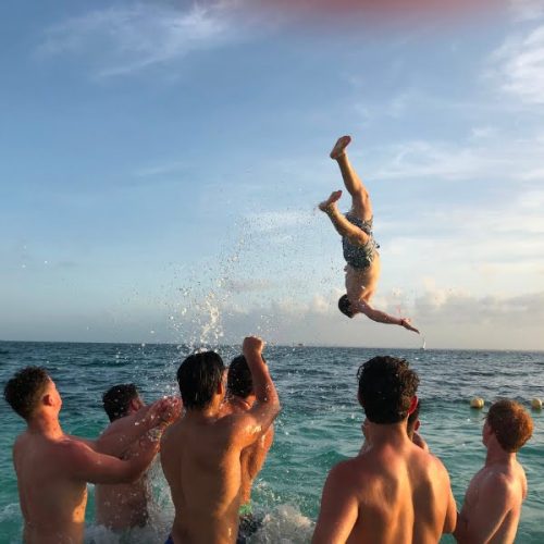 A group of men jumping into the water.