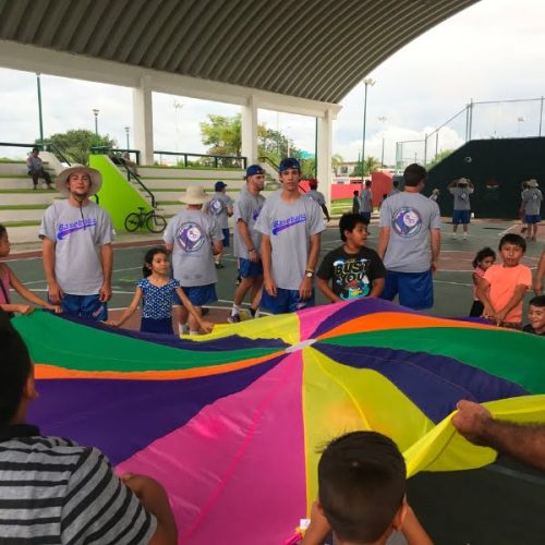 A group of people standing around a colorful kite.