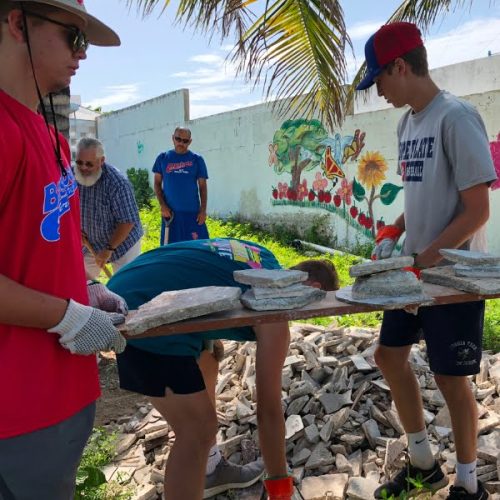 A group of people working on a pile of rubble.