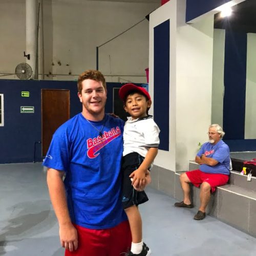 A man holding a young boy in a gym.